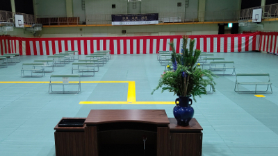 大阪府立大阪北視覚支援学校の体育館の写真。卒業式のために椅子や誘導マットが配置されています。