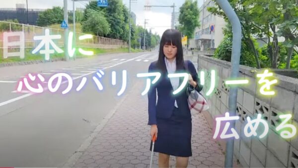 日本に心のバリアフリーを広めると書かれた文字と白杖つかって歩く杉本梢さんが映るユーチューブのサムネイル画像