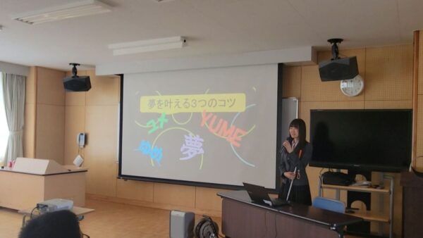 プロジェクターの前で講演をする杉本梢さん